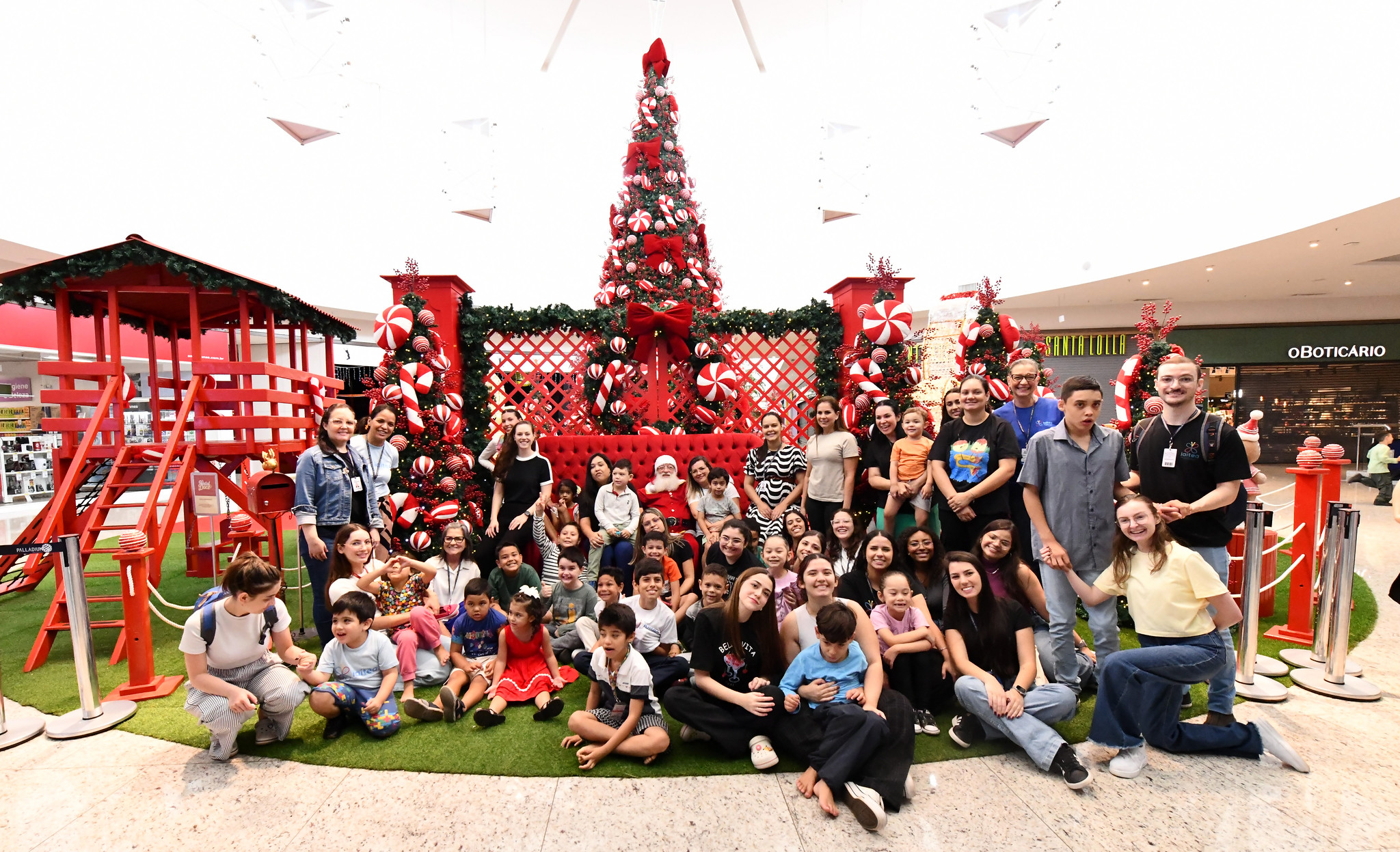 crianças e professores do instituto posam ao lado do papai noel no shopping