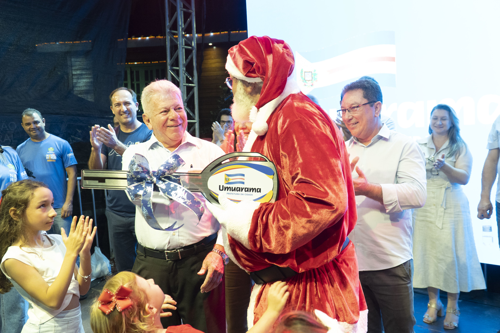 papai noel recebe a chave da cidade das mãos do prefeito