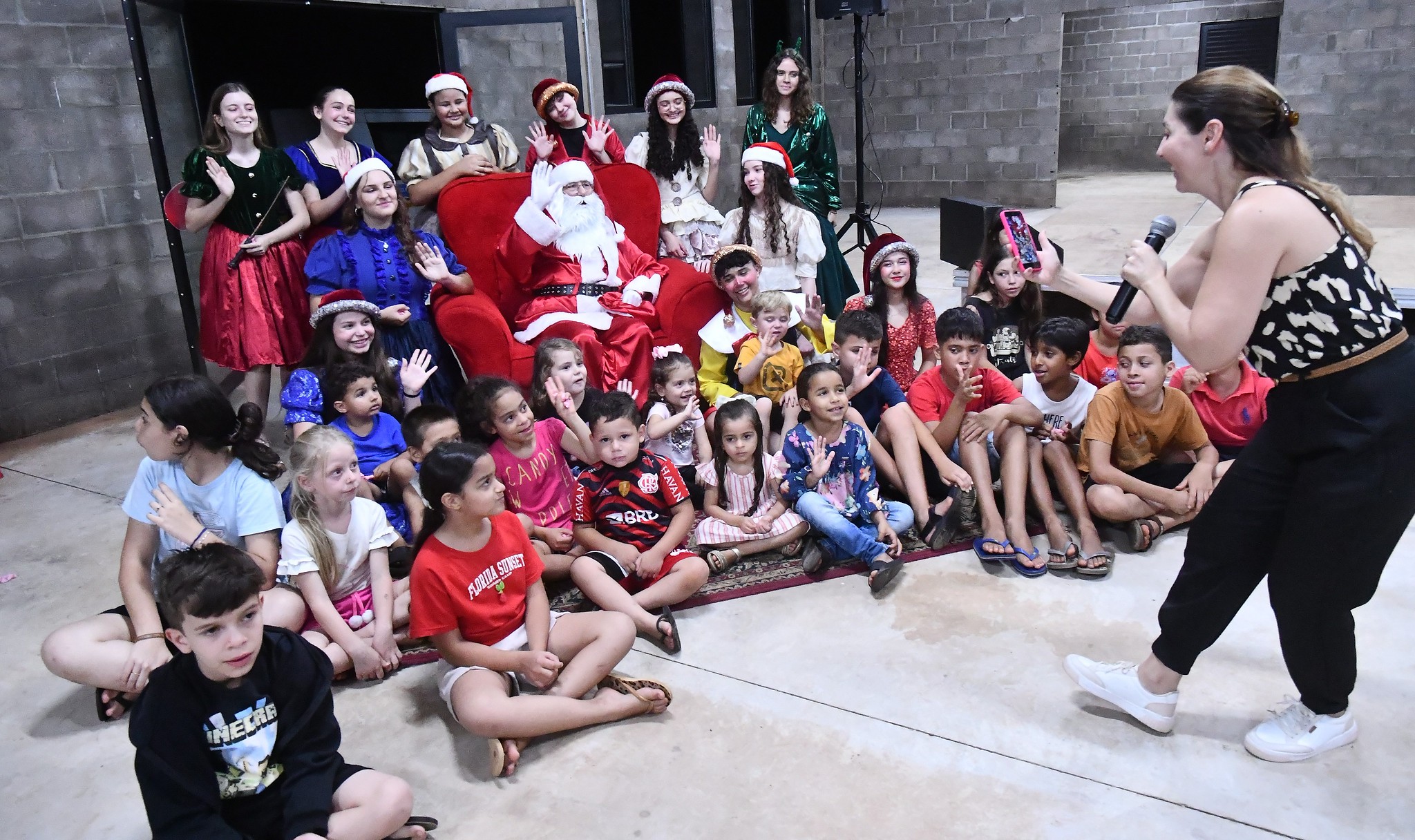 papai noel posa para foto com as crianças e artistas