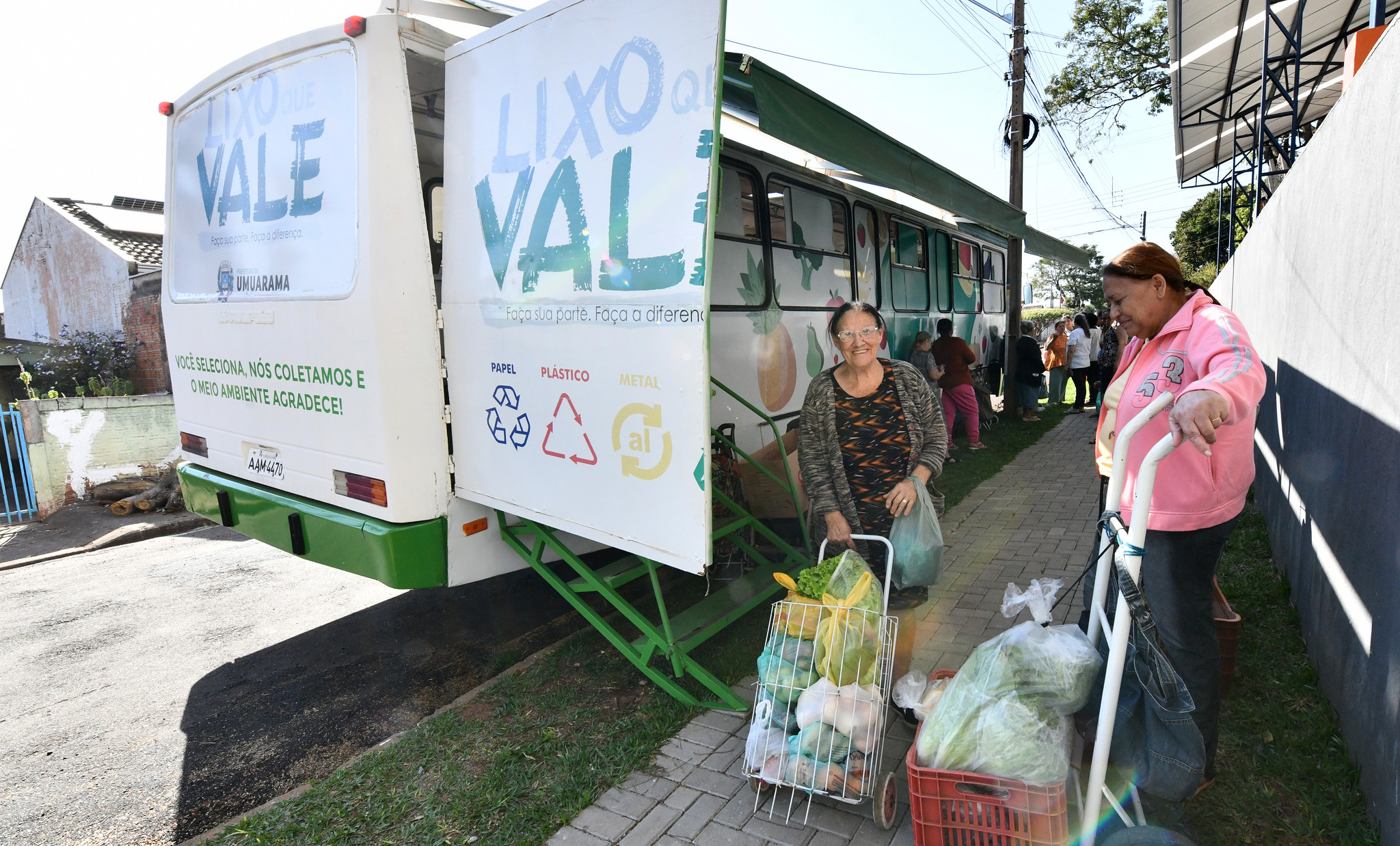 imagem de moradora contente com carrinho de alimentos adquiridos no ônibus do programa
