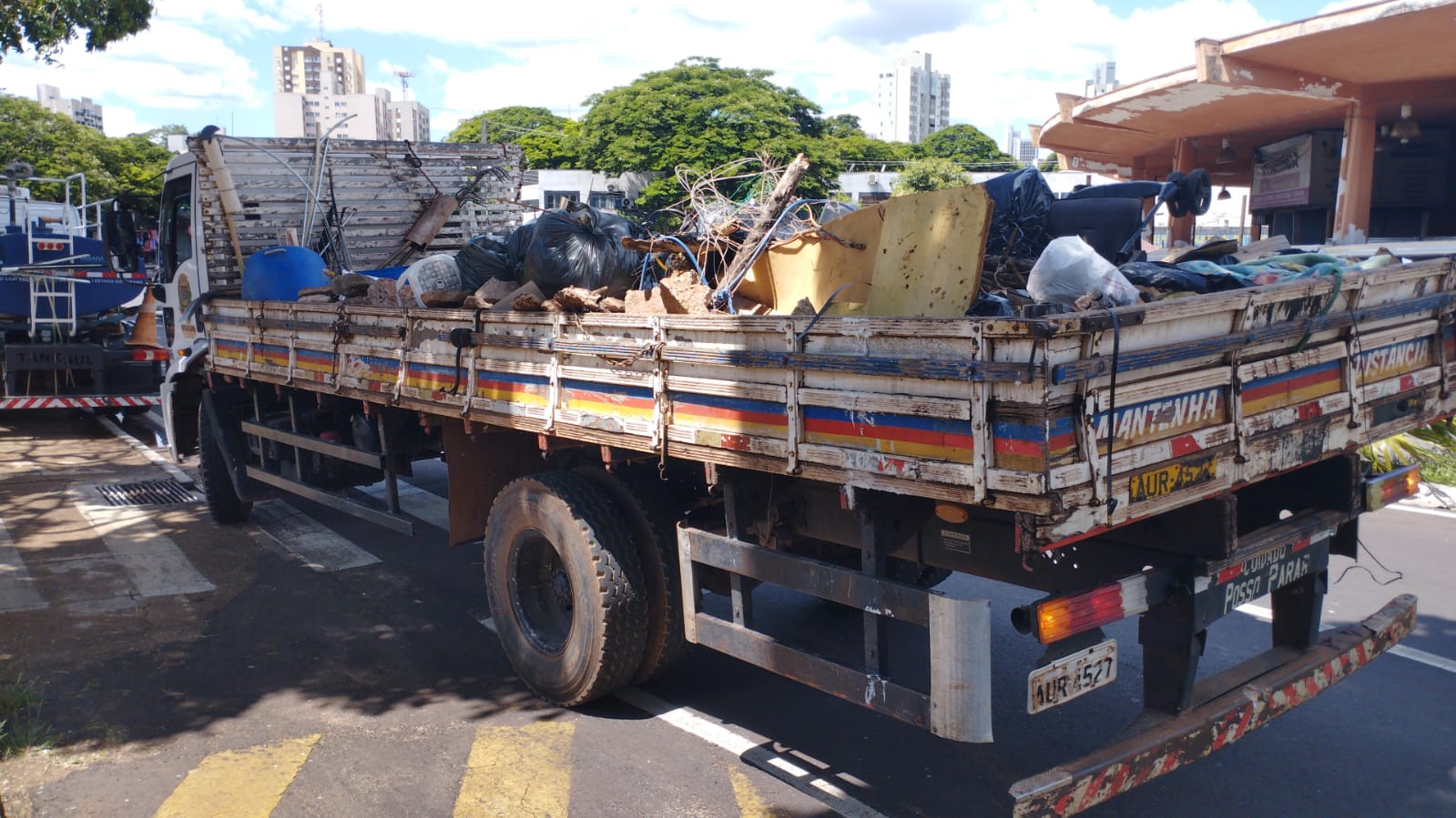 imagem de caminhão lotado de lixo e entulho recolhido da praça