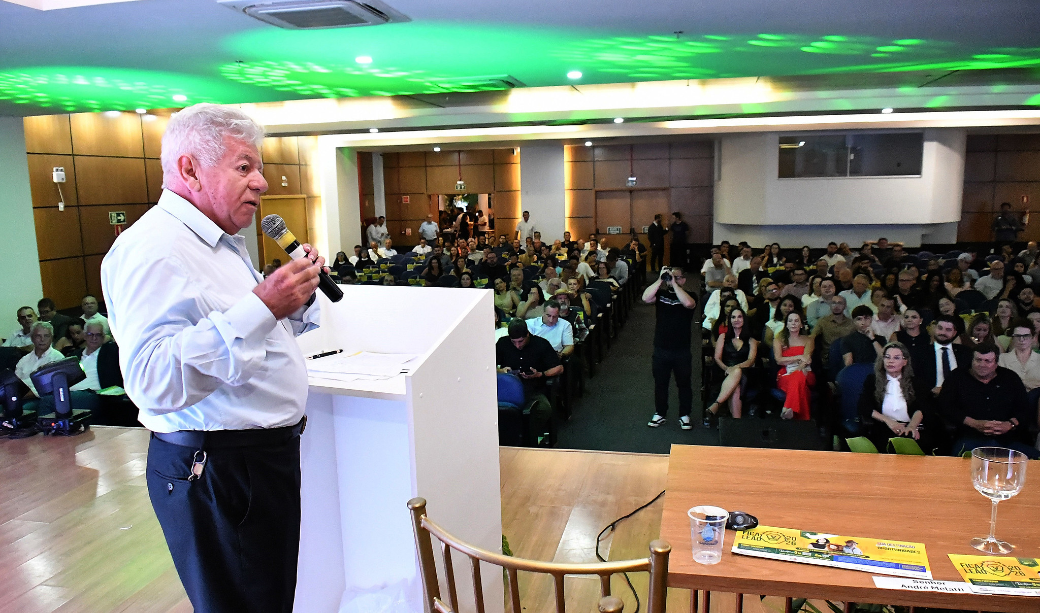 prefeito discursa no púlpito diante de grande plateia