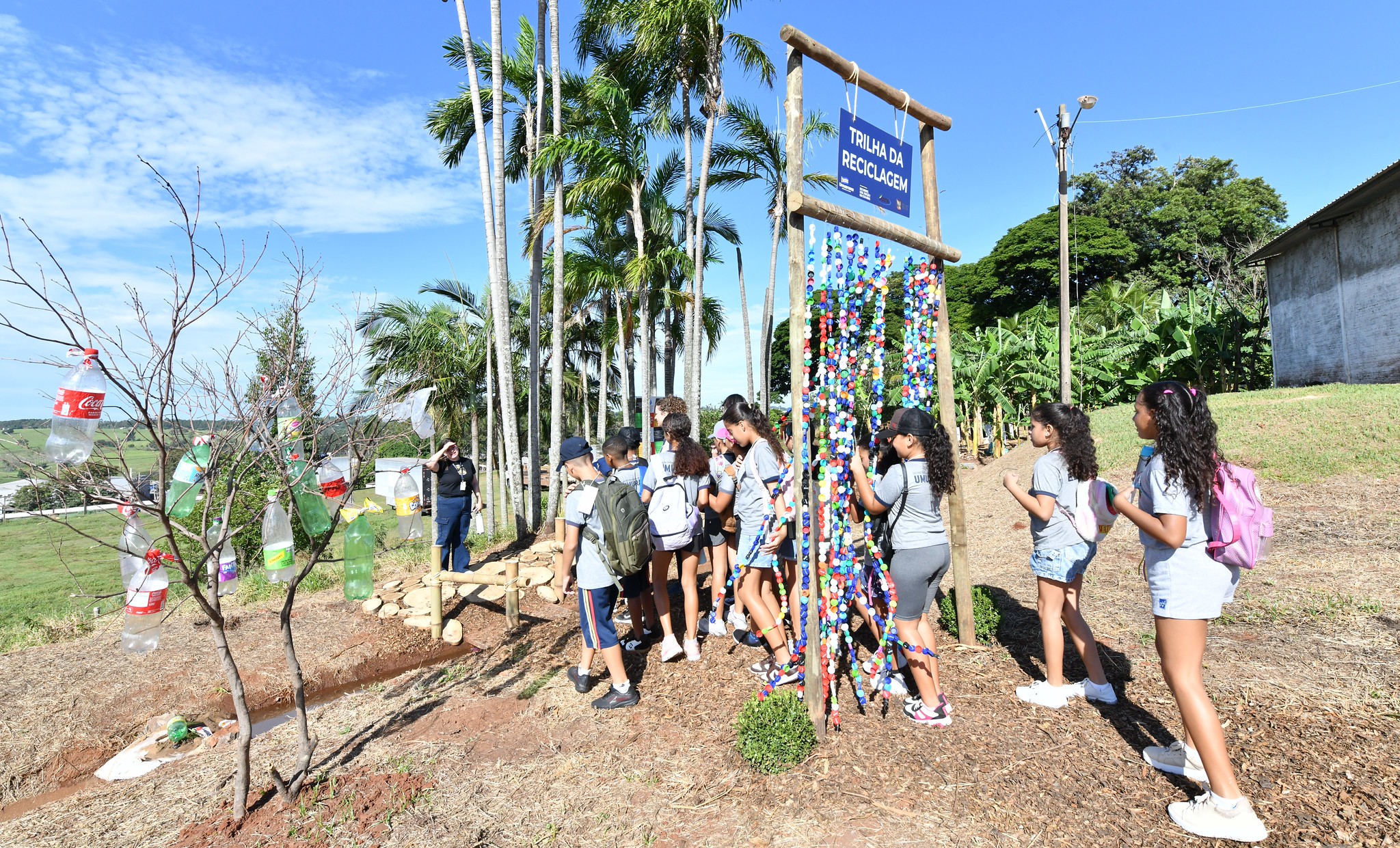 crianças visitam trilha com orientações sobre reciclagem de resíduos