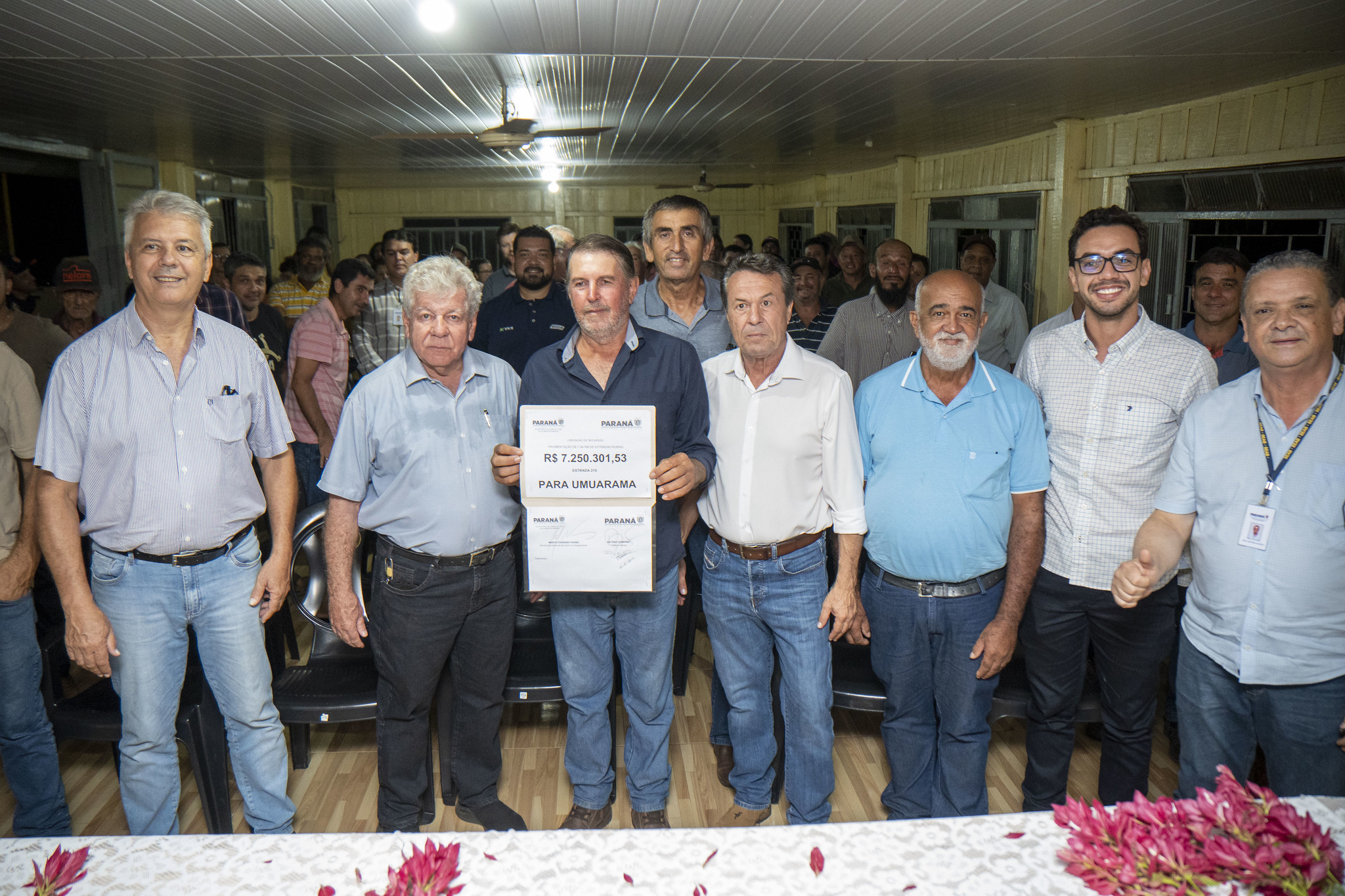 autoridades mostram cartaz com valor da obra e produtores rurais ao fundo