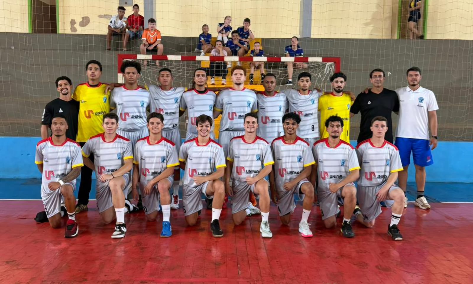 foto do time masculino de handebol posando em formação na quadra esportiva