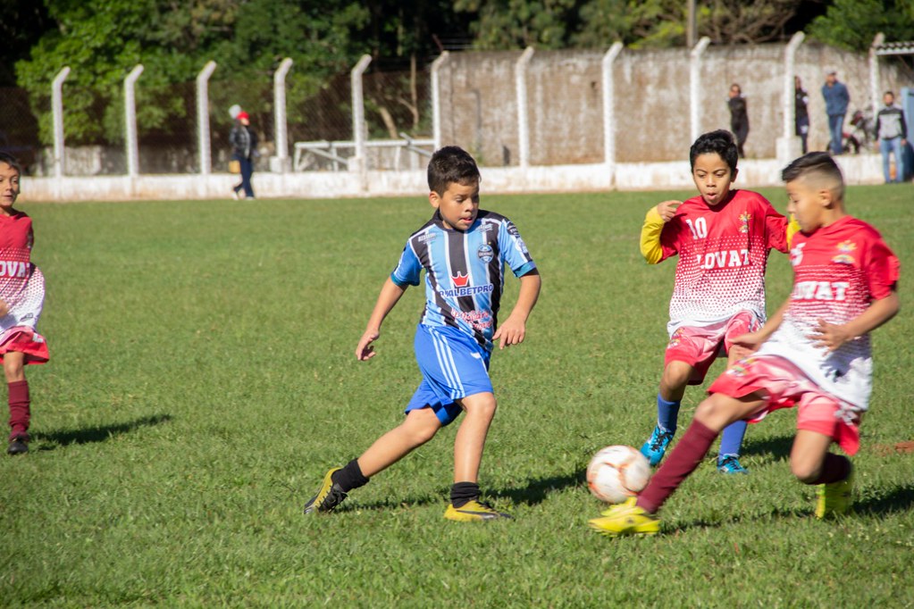 jogo de futebol com atletas infantis disputando jogada
