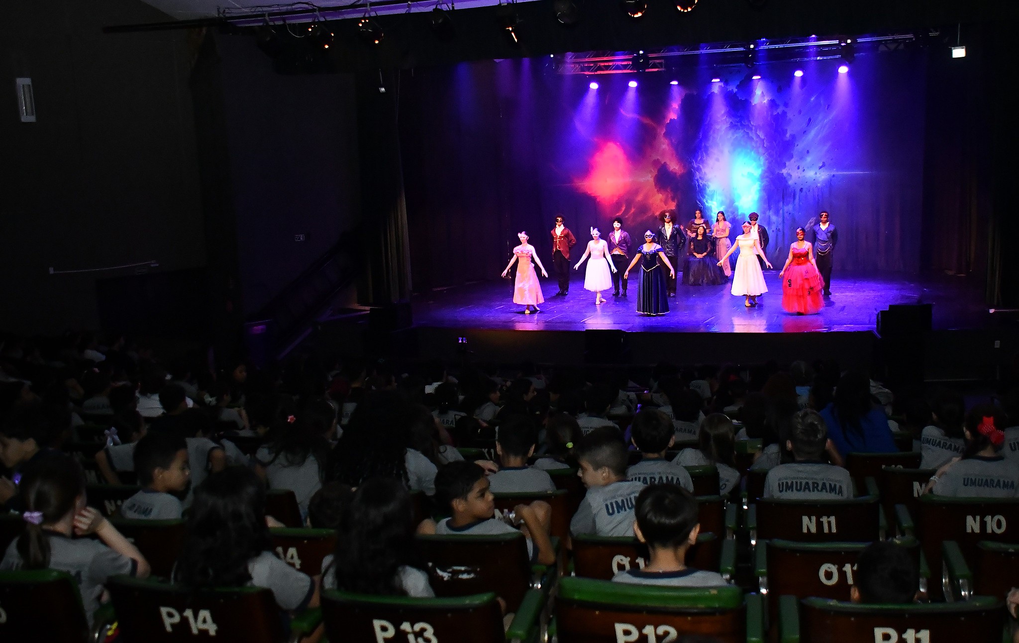 alunos na plateia assistem apresentação teatral