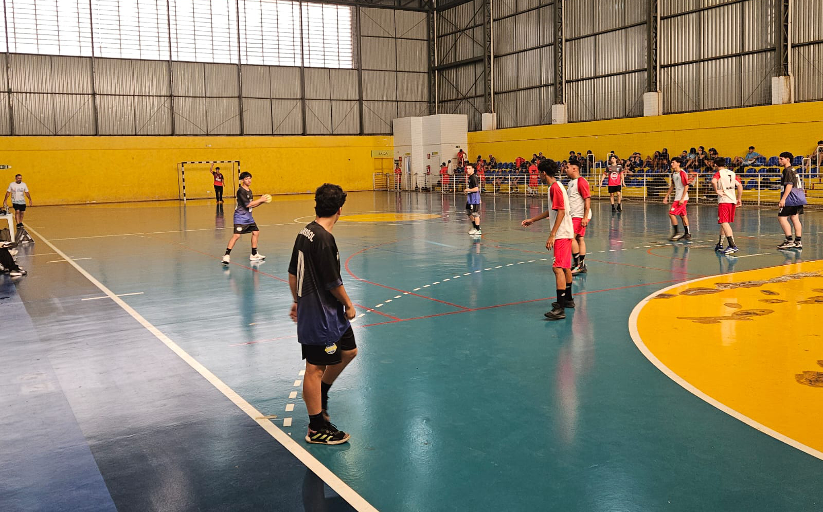 jogo de handebol masculino disputado em quadra esportiva