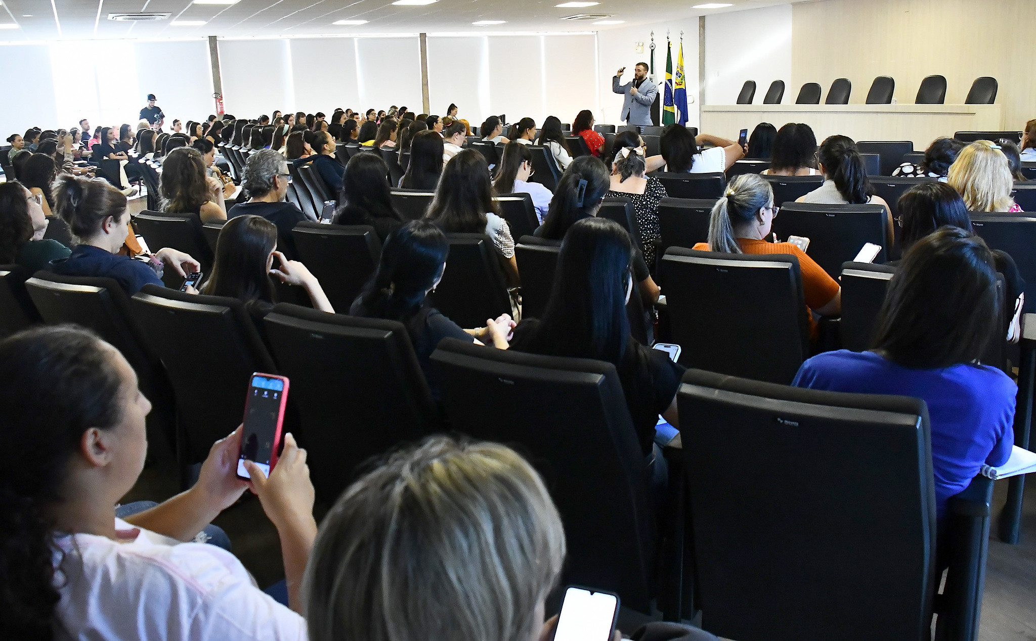 palestra no auditório da prefeitura, lotado de professores