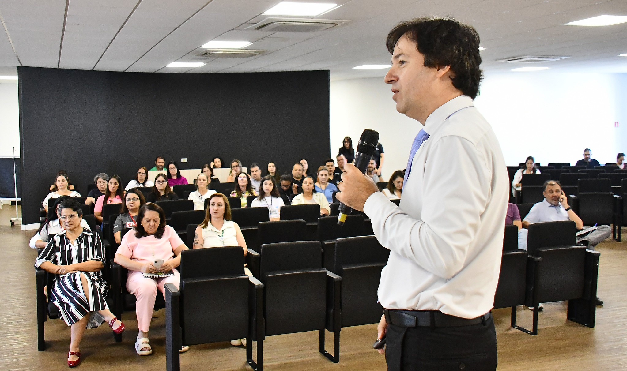 procurador fala ao público, acomodado nas cadeiras do auditório