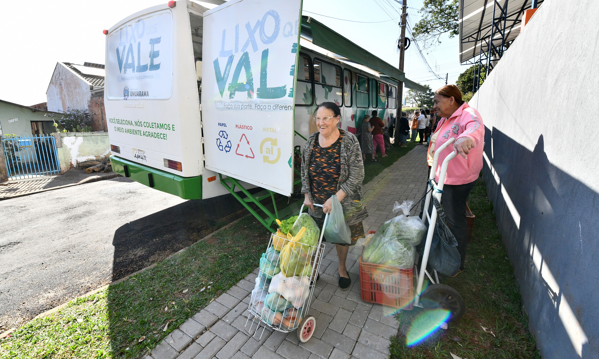 mulheres levam frutas e verduras adquiridas no ônibus do programa