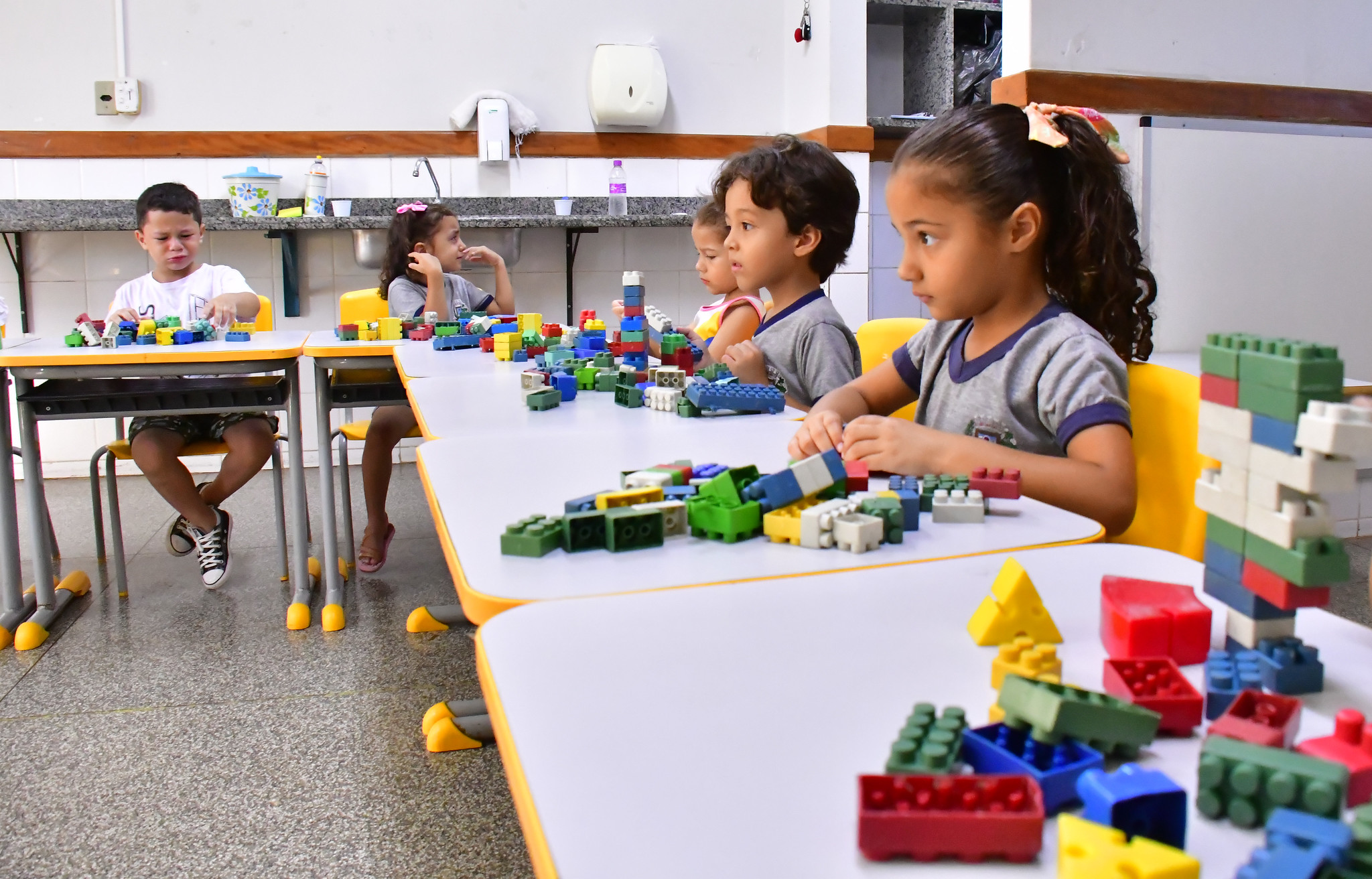 crianças brincando em mesa, na sala de aula