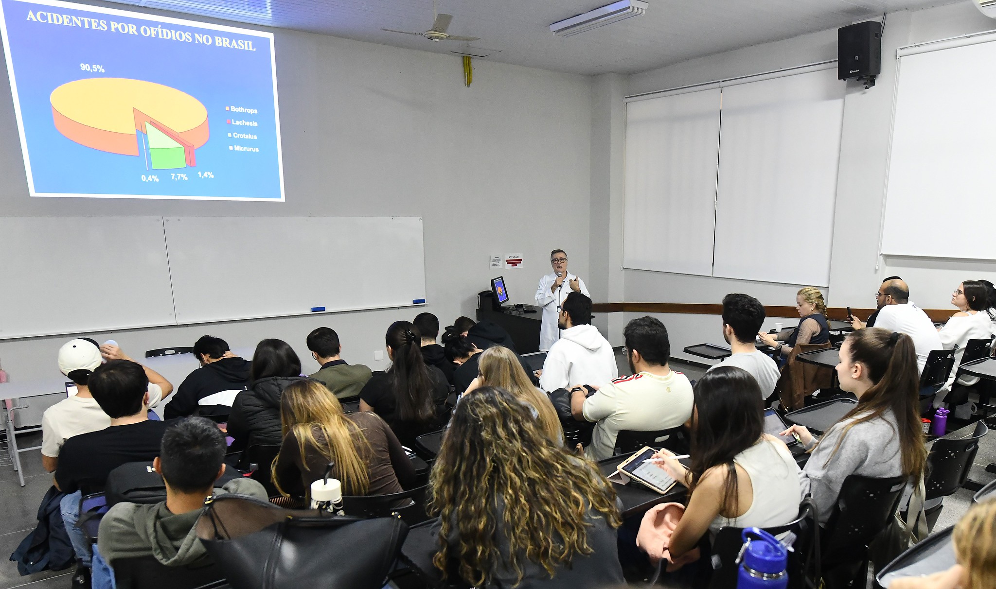 médico fala para alunos de medicina num auditório
