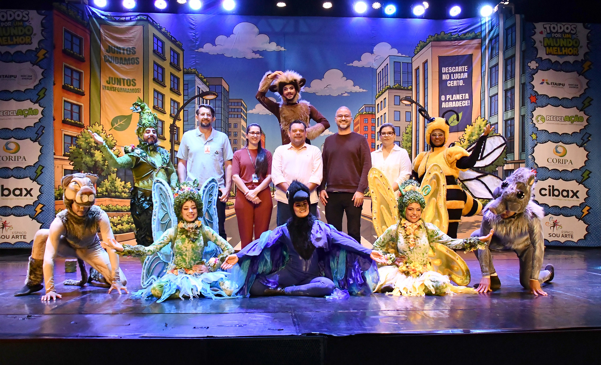 artistas e autoridades no palco do teatro