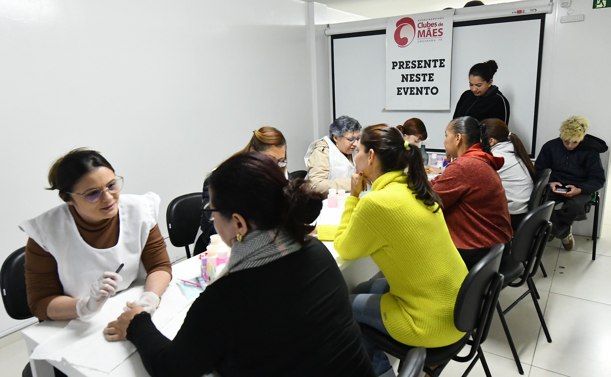 mães fazem as unhas com alunos do clube de mães
