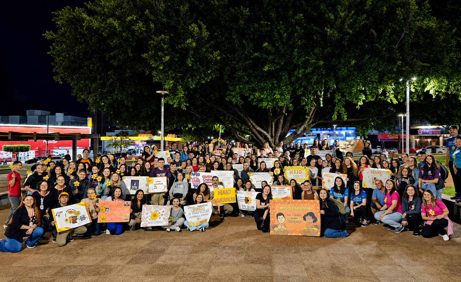 equipe da rede de atendimento/assistência reunida em praça pública com faixas e cartazes em defesa das crianças e adolescentes