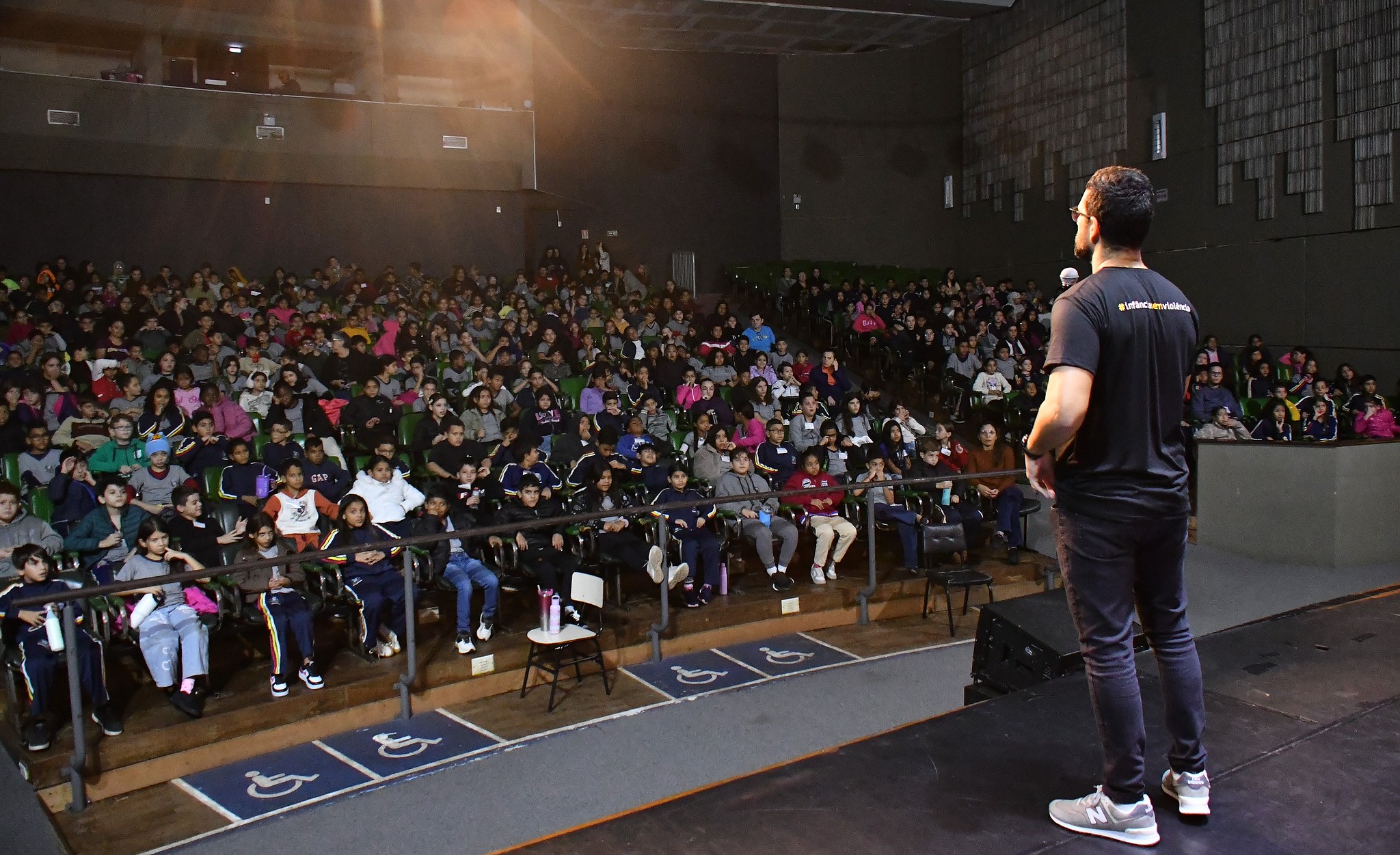 promotor fala para o teatro lotado de crianças