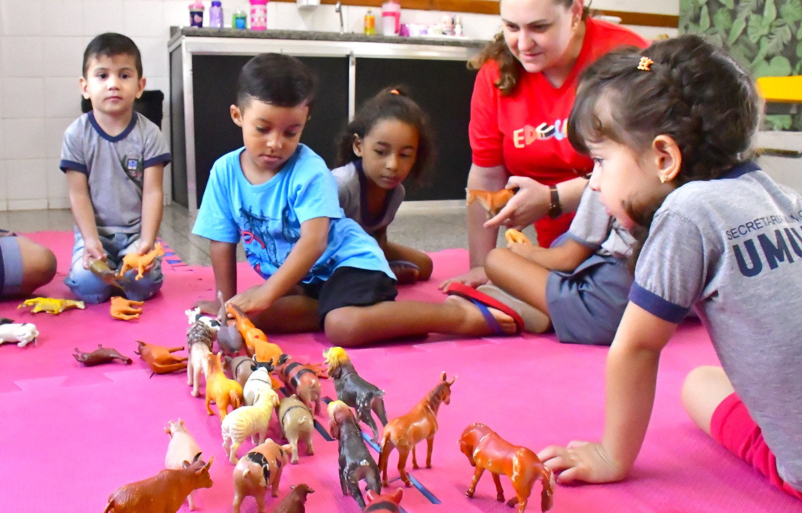 crianças brincando em tapete na escola