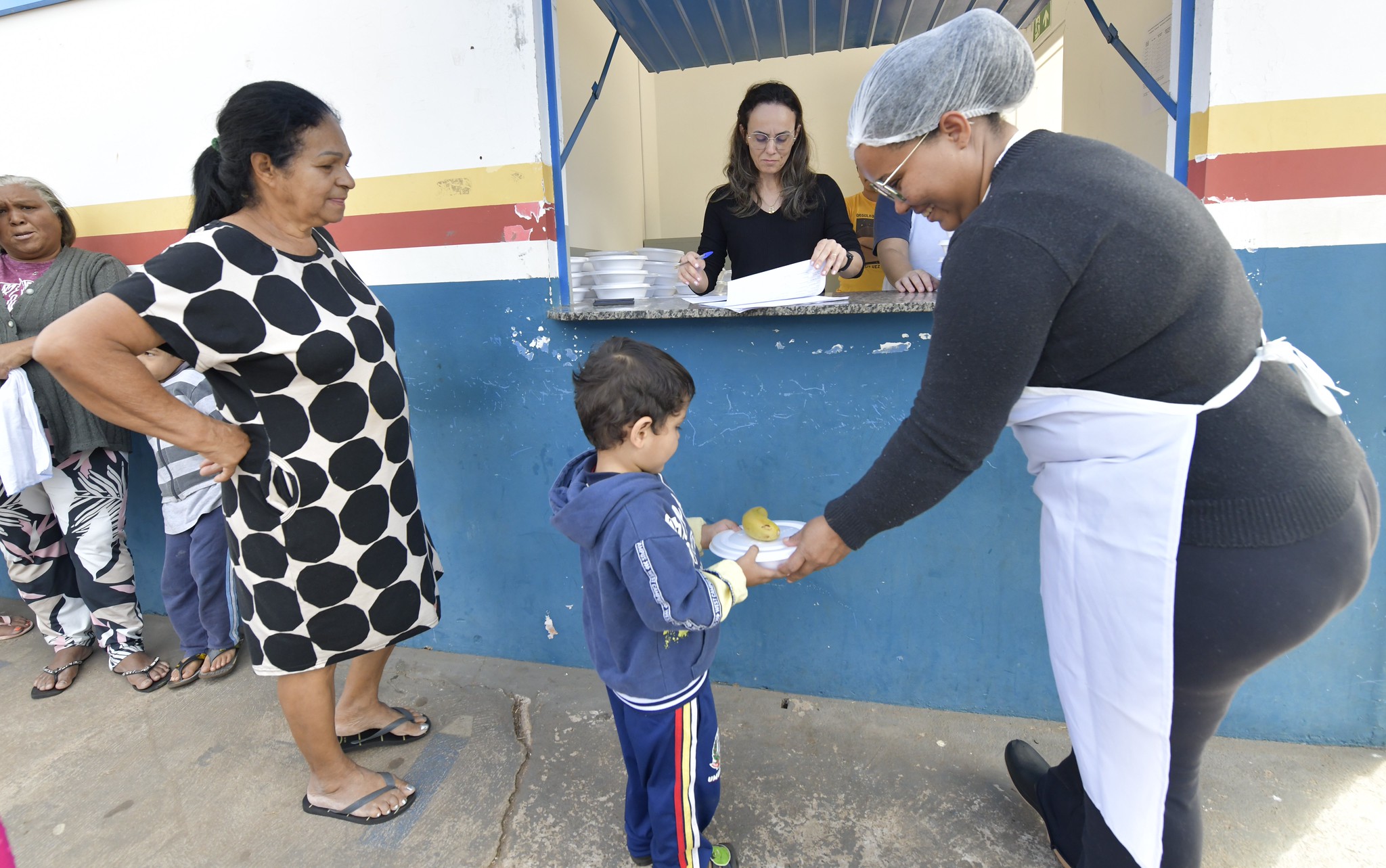 merendeira entrega refeição para criança