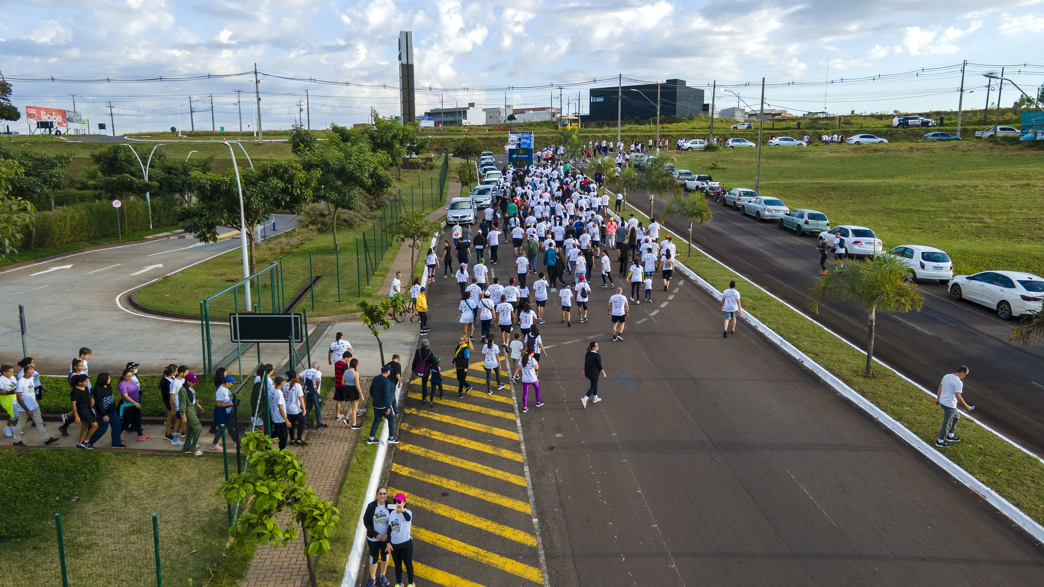início da caminhada, com participantes saindo do shopping