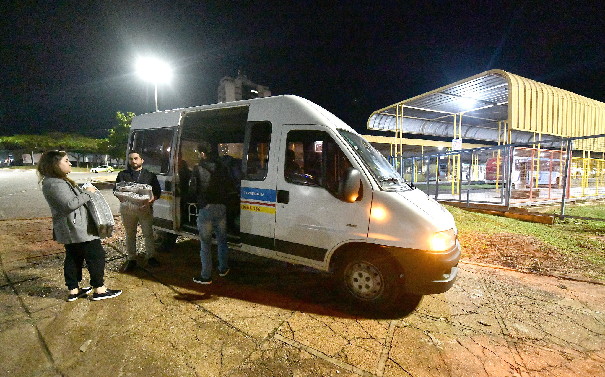equipe em veículo da assistência social entrega cobertores para andarilhos
