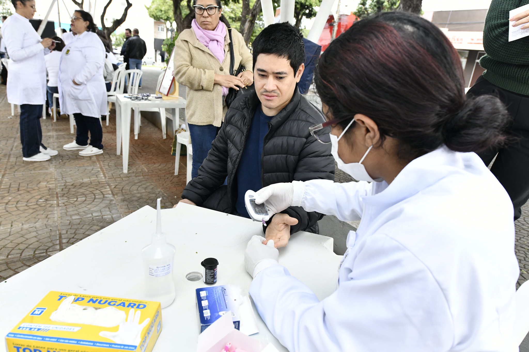 enfermeira realiza teste de glicemia em homem