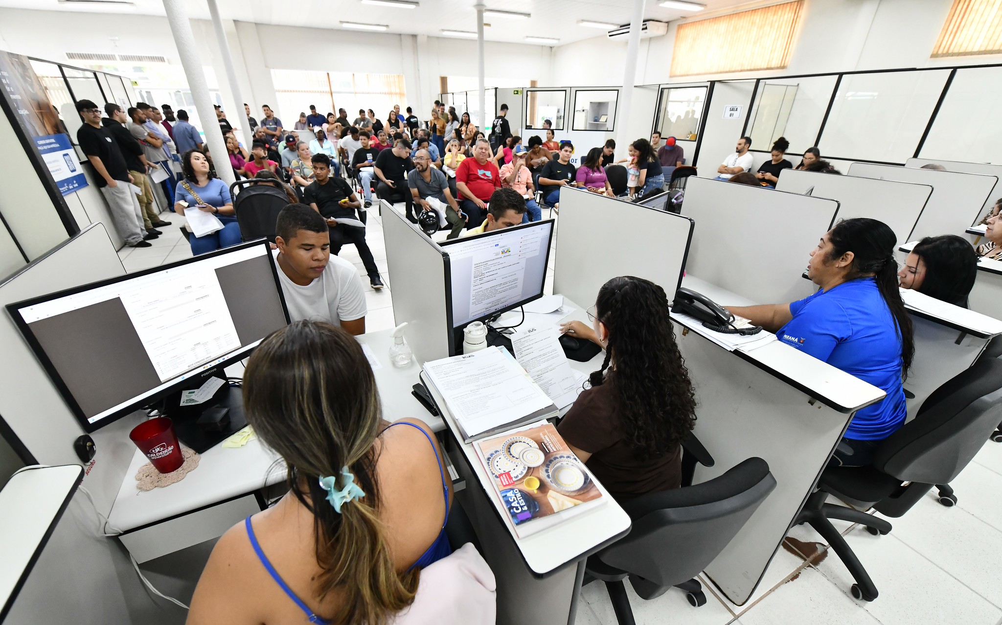 pessoas sendo atendidas nos guichês da agência do trabalhador