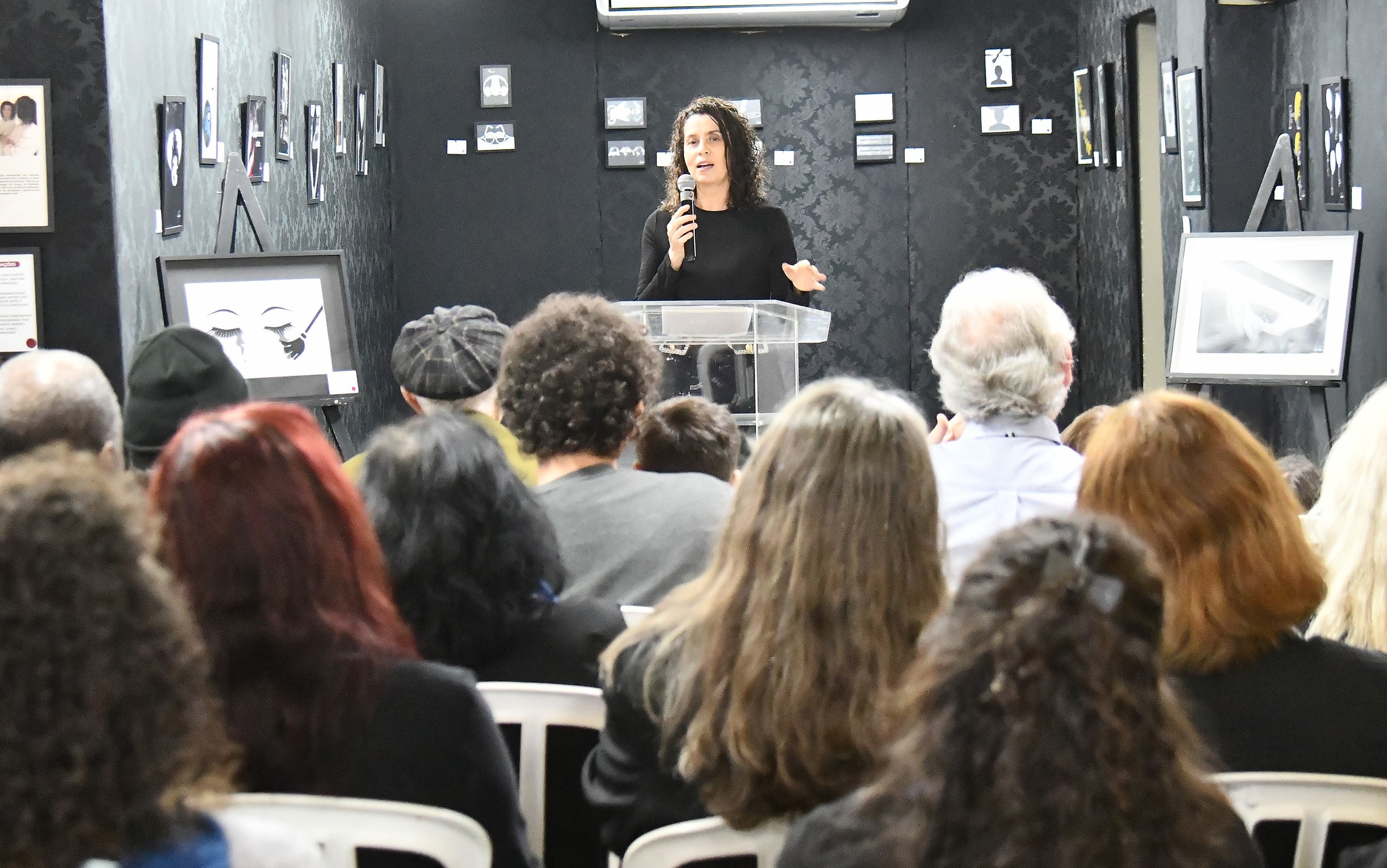 a artista plástica fala à plateia na abertura da exposição