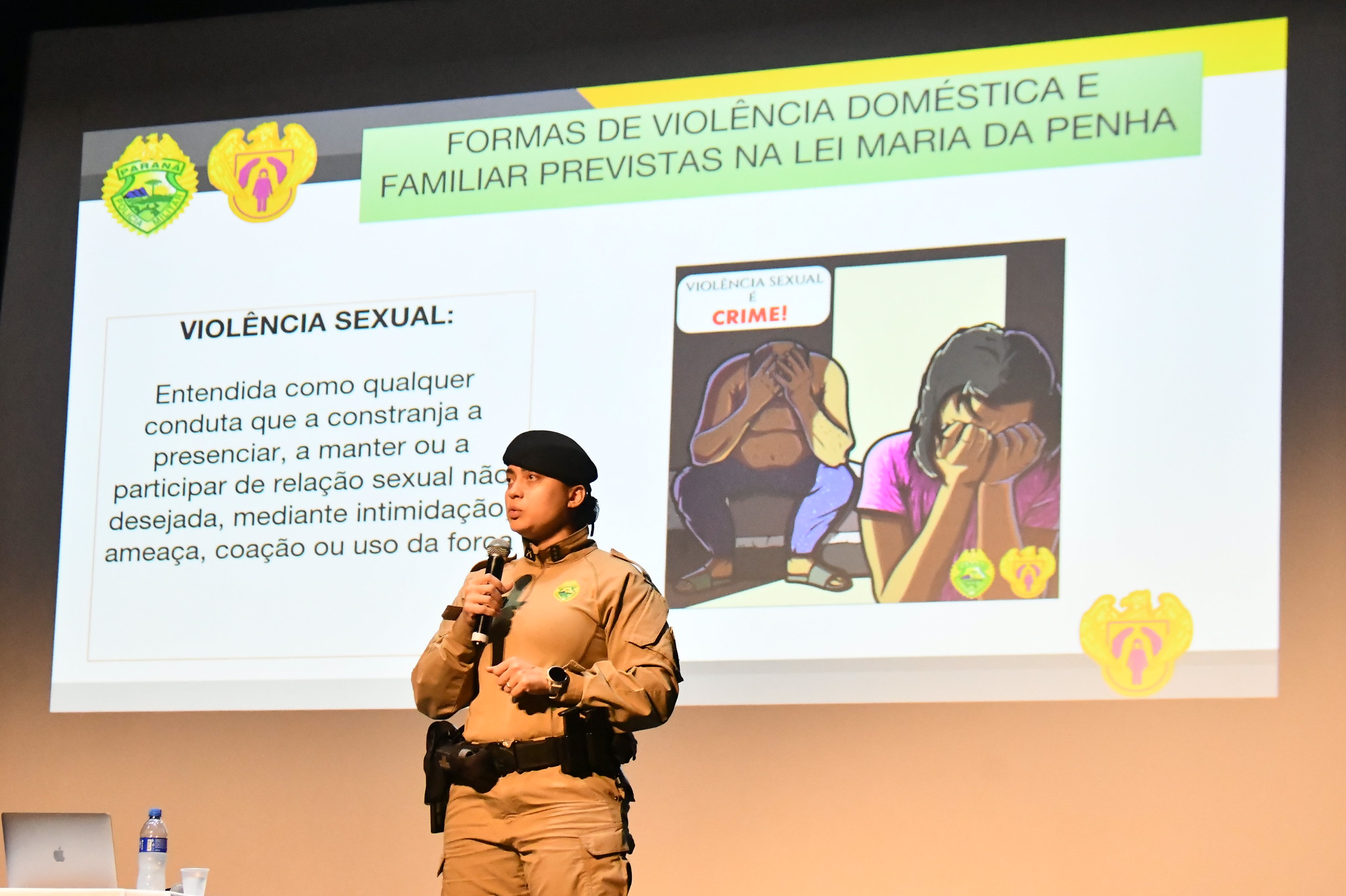 capitã da polícia militar fala, diante de telão