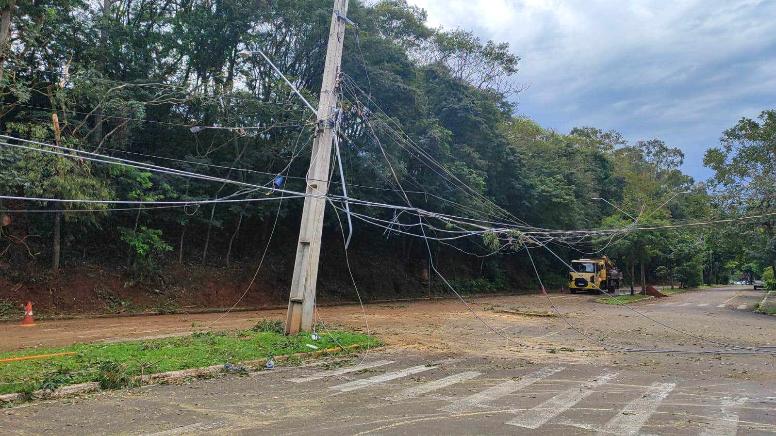pá carregadeira e equipes retiram árvores caídas em estrada