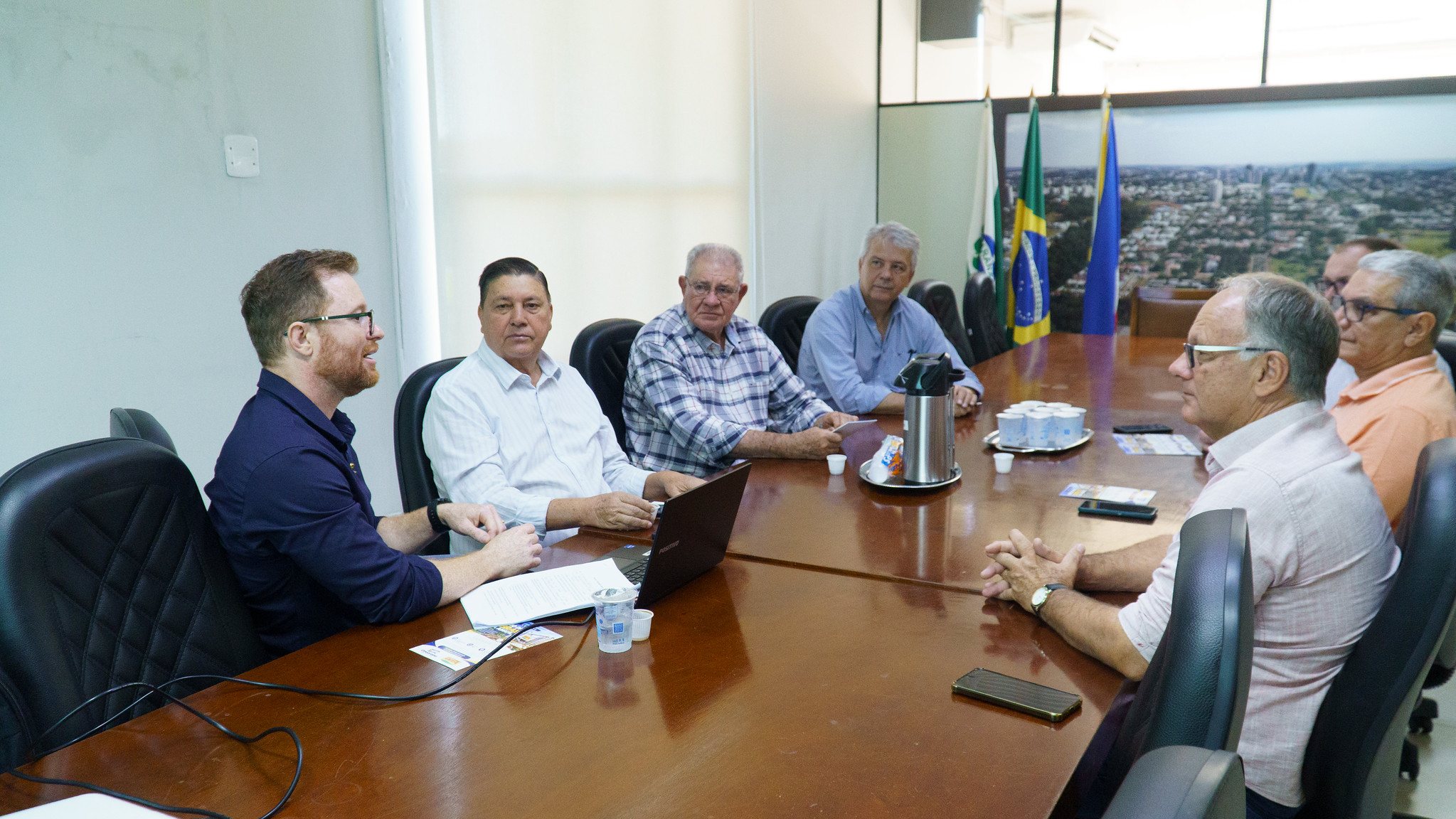 homens reunidos em torno de uma mesa, em reunião