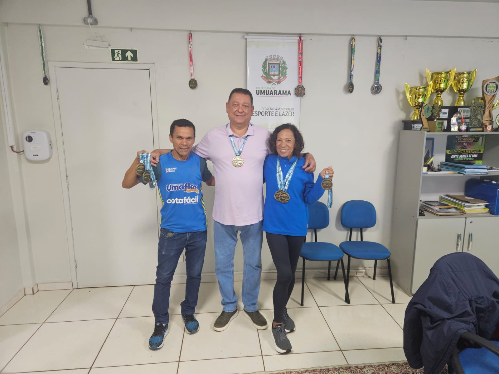 atletas se encontram com o secretário de esportes e exibem medalhas