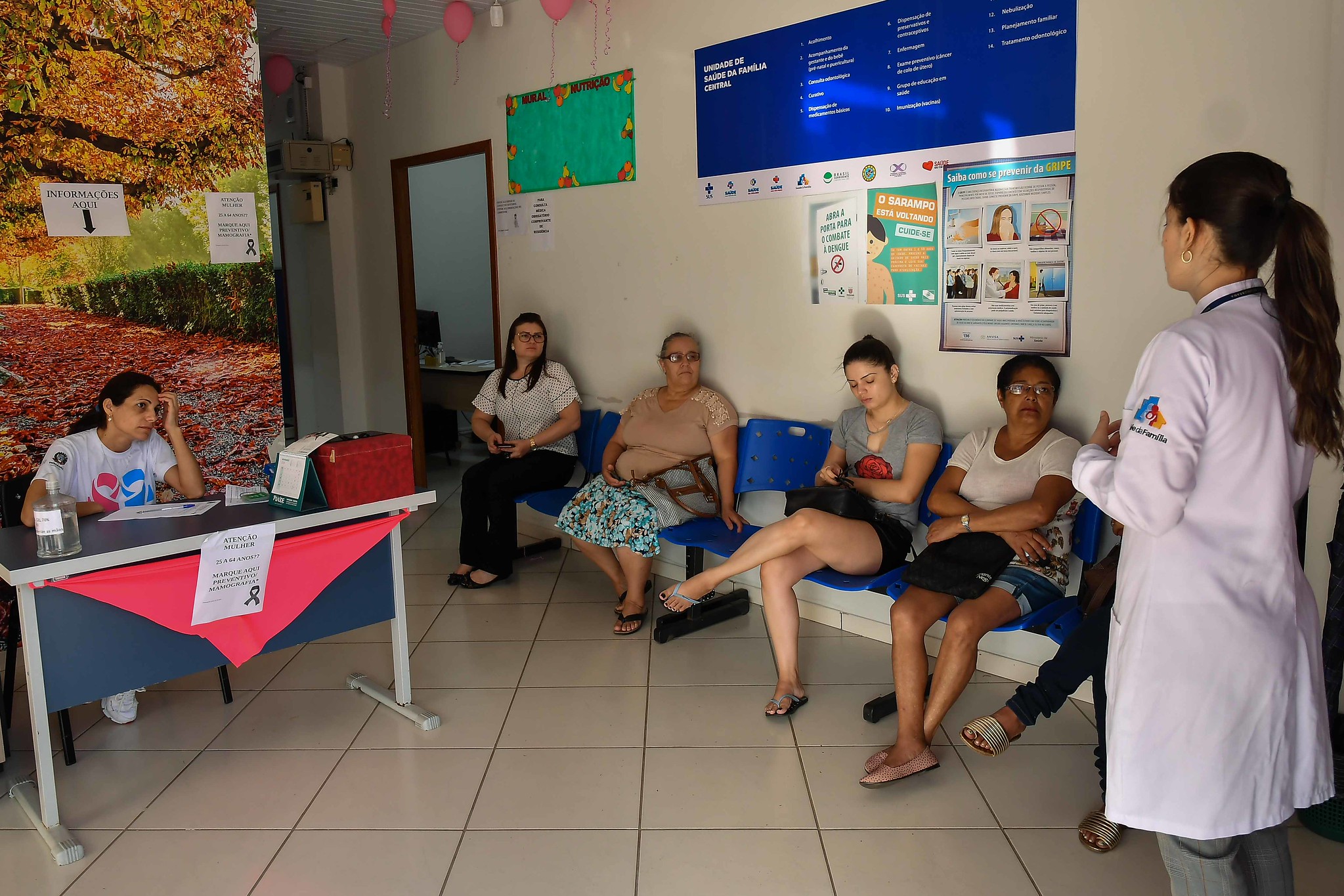 enfermeira fala com pacientes em unidade de saúde