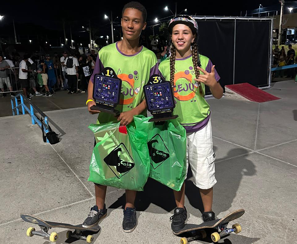 OS JOVENS ATLETAS FAZEM POSE PARA FOTO COM TROFÉUS E SKATES