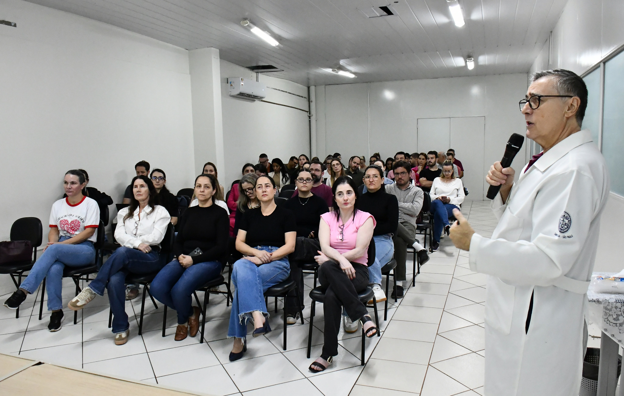 médico fala aos participantes da palestra