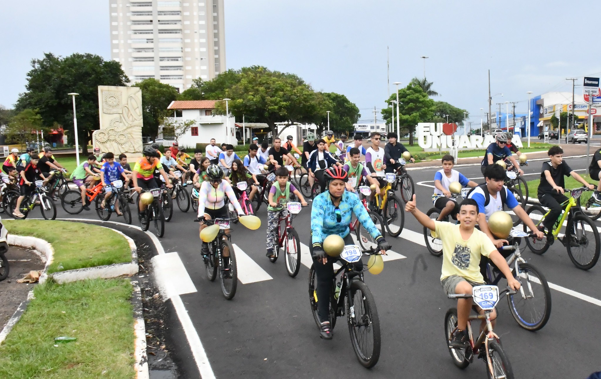 crianças e adultos pedalando bicicletas em via pública